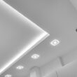 Najlepsze rodzaje oświetlenia salonu według architektów: lampa sufitowa z listwami LED versus halogeny